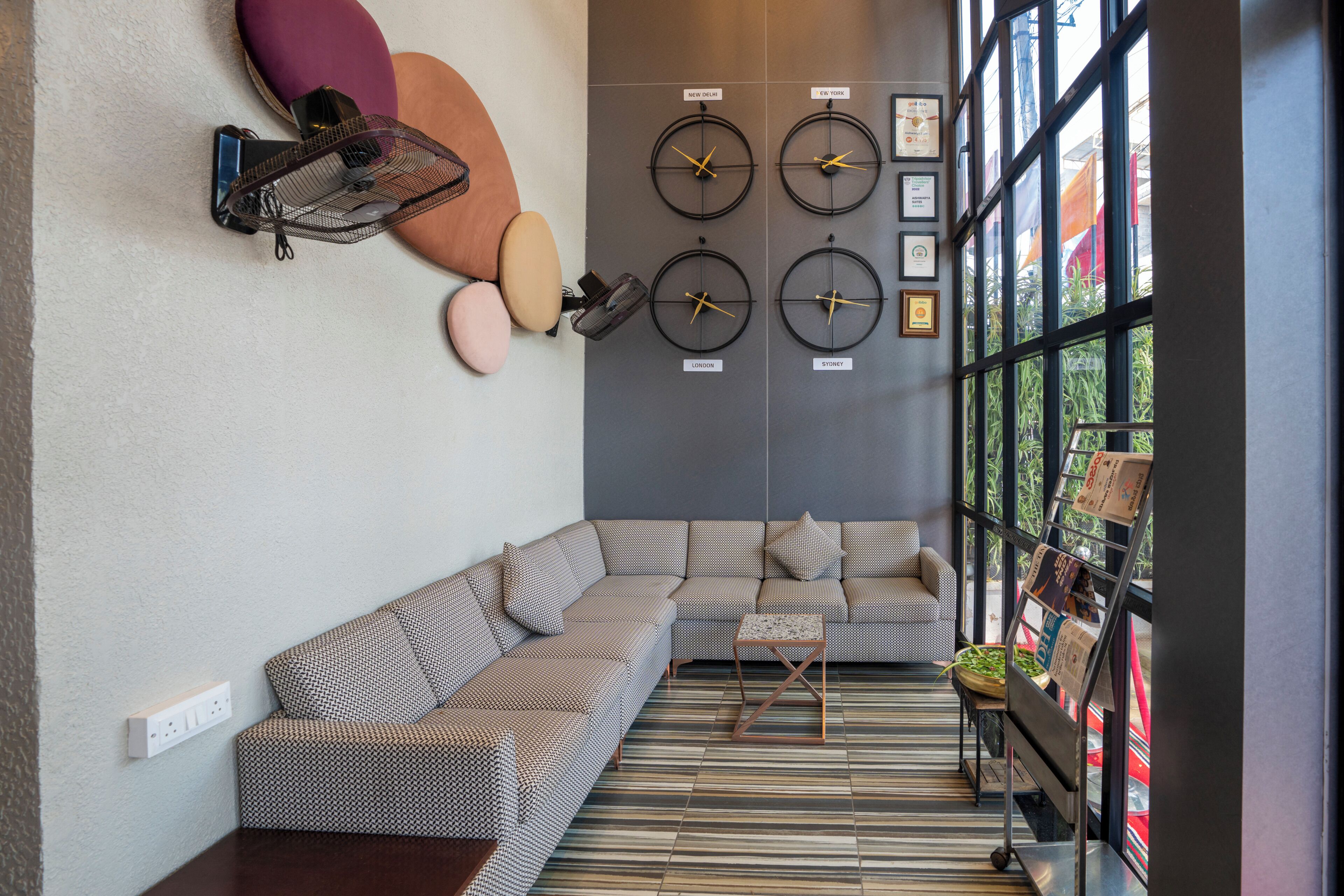 Una sala de estar moderna con un sofá modular, una pequeña mesa de centro y un reloj fijado a la pared.