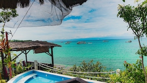 Zona de piscina con vistas al océano y a los barcos.