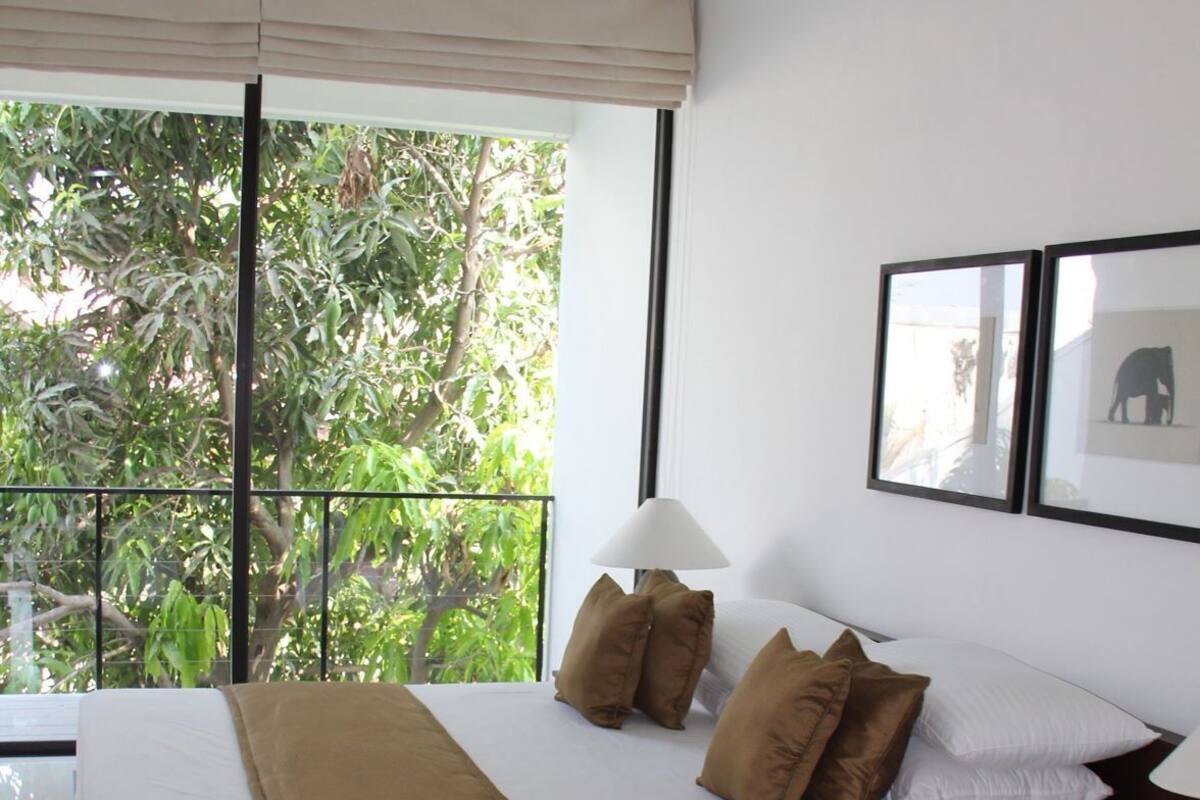 A bedroom with a bed, a nightstand, a lamp, and a ceiling fan.