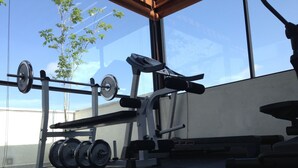 A gym with a weight bench, a squat rack, and a barbell with weights. - Rockwell Colombo (Colombo)