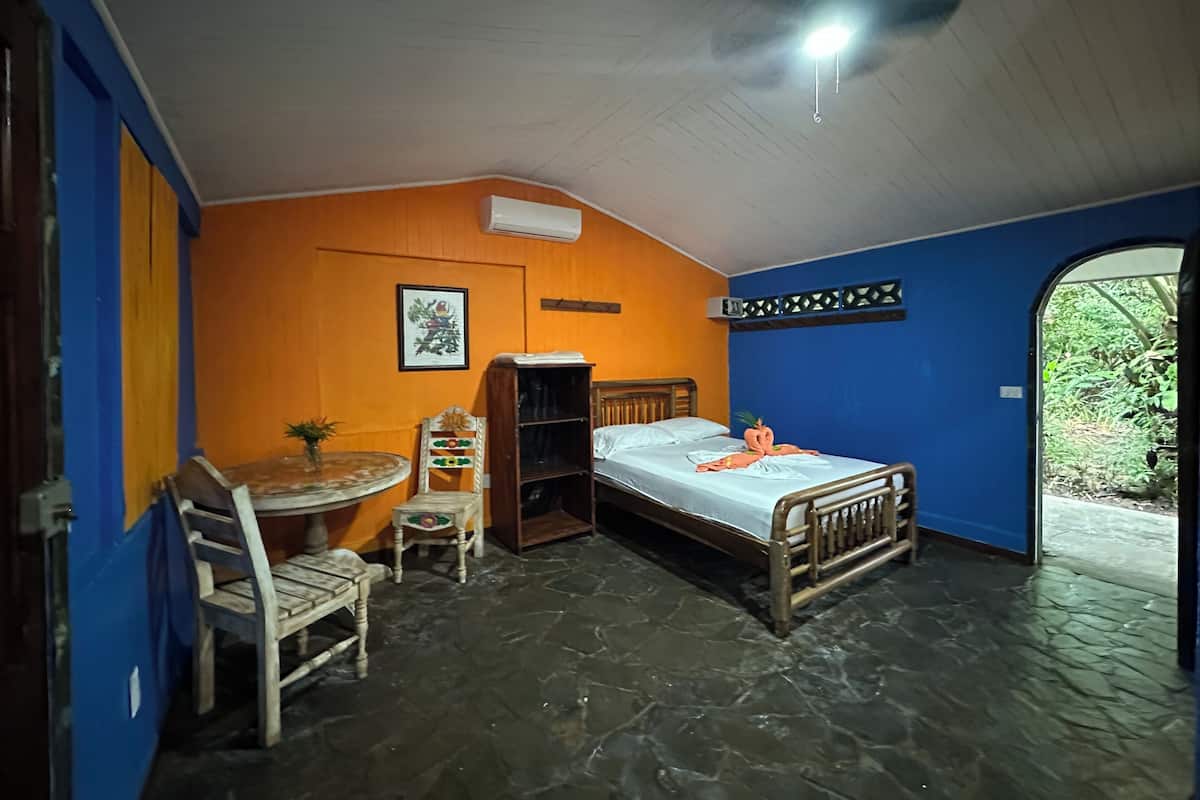 Een kamer met een bed, een bureau, een stoel en een kleine tafel.