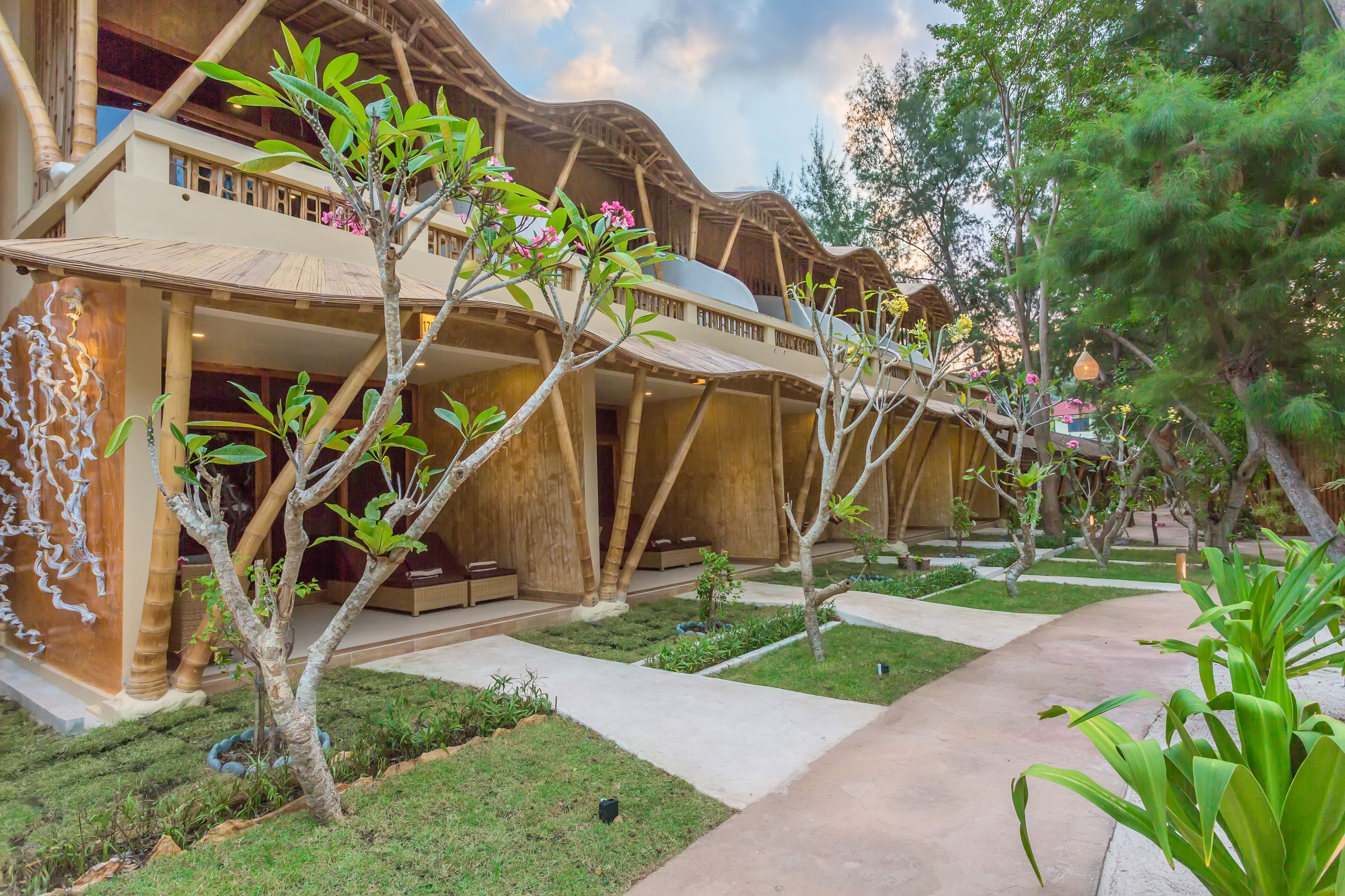 A resort with a unique wooden architecture, a well-maintained garden, and a clear pathway.