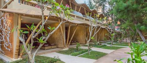 A resort with a unique wooden architecture, a well-maintained garden, and a clear pathway.