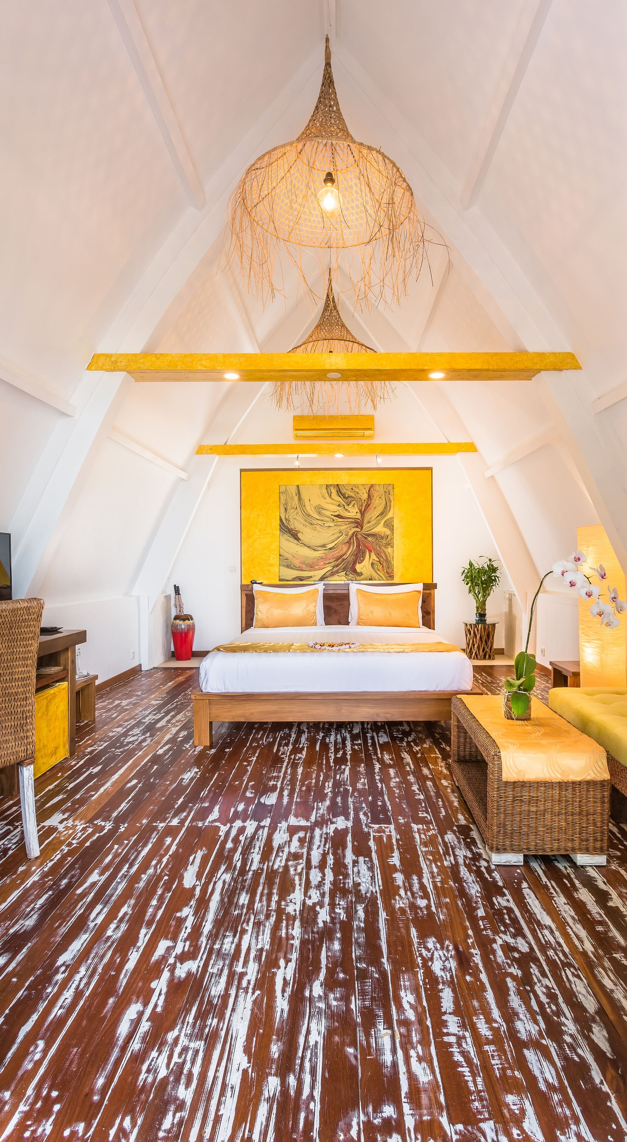 Un dormitorio con una cama grande, una lámpara colgante y un cuadro en la pared.