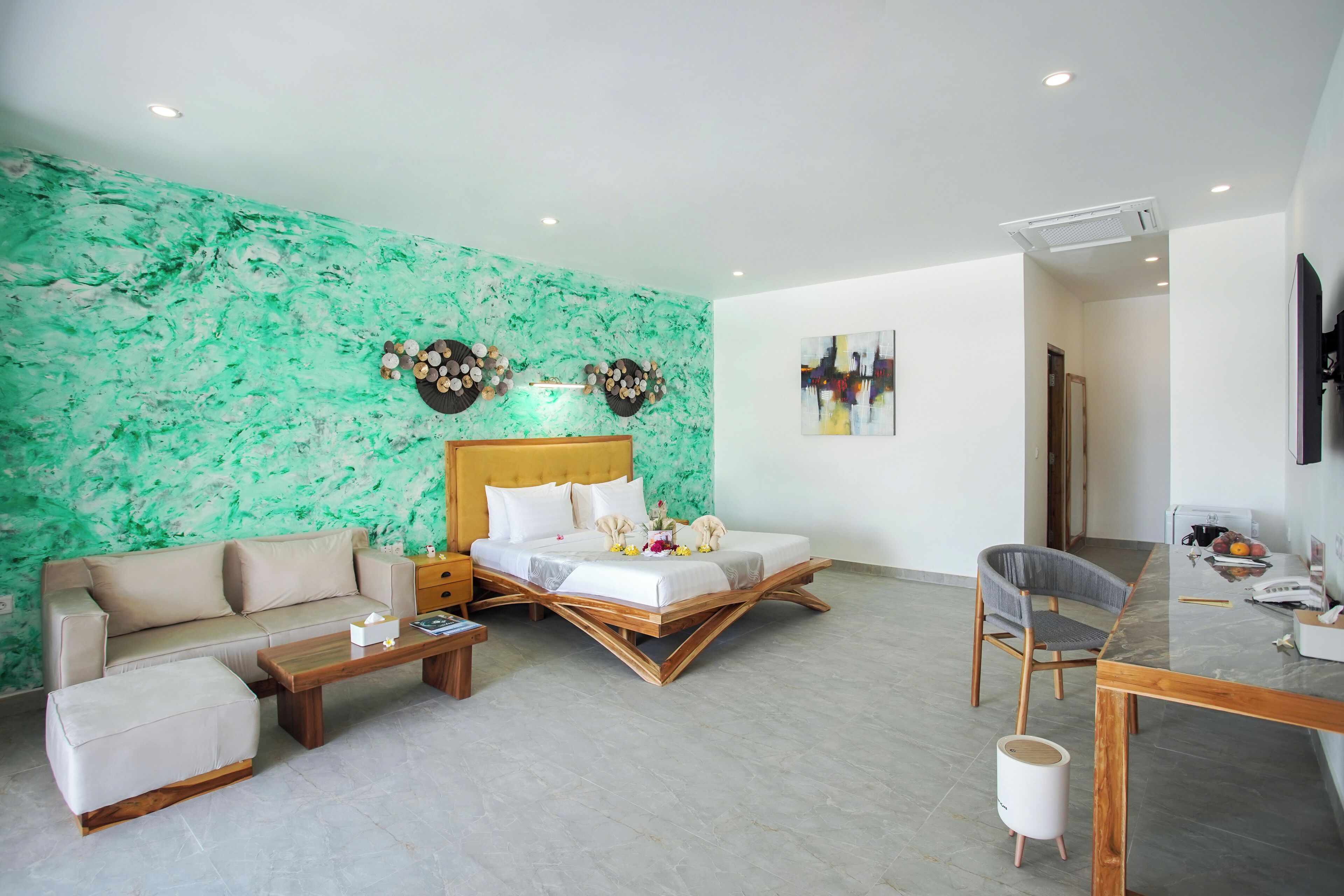 Een moderne hotelkamer met een bed, een bank en een eettafel.