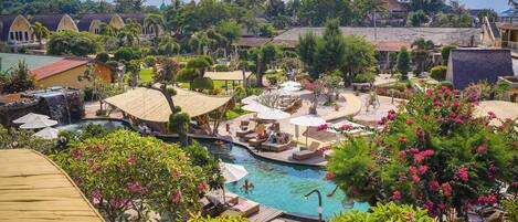 Un resort con piscina, zonas de descanso y vistas del paisaje circundante.