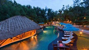 A poolside area with lounge chairs and umbrellas, a thatched-roof structure, and a wooden deck. - Pearl of Trawangan (Gili Trawangan)