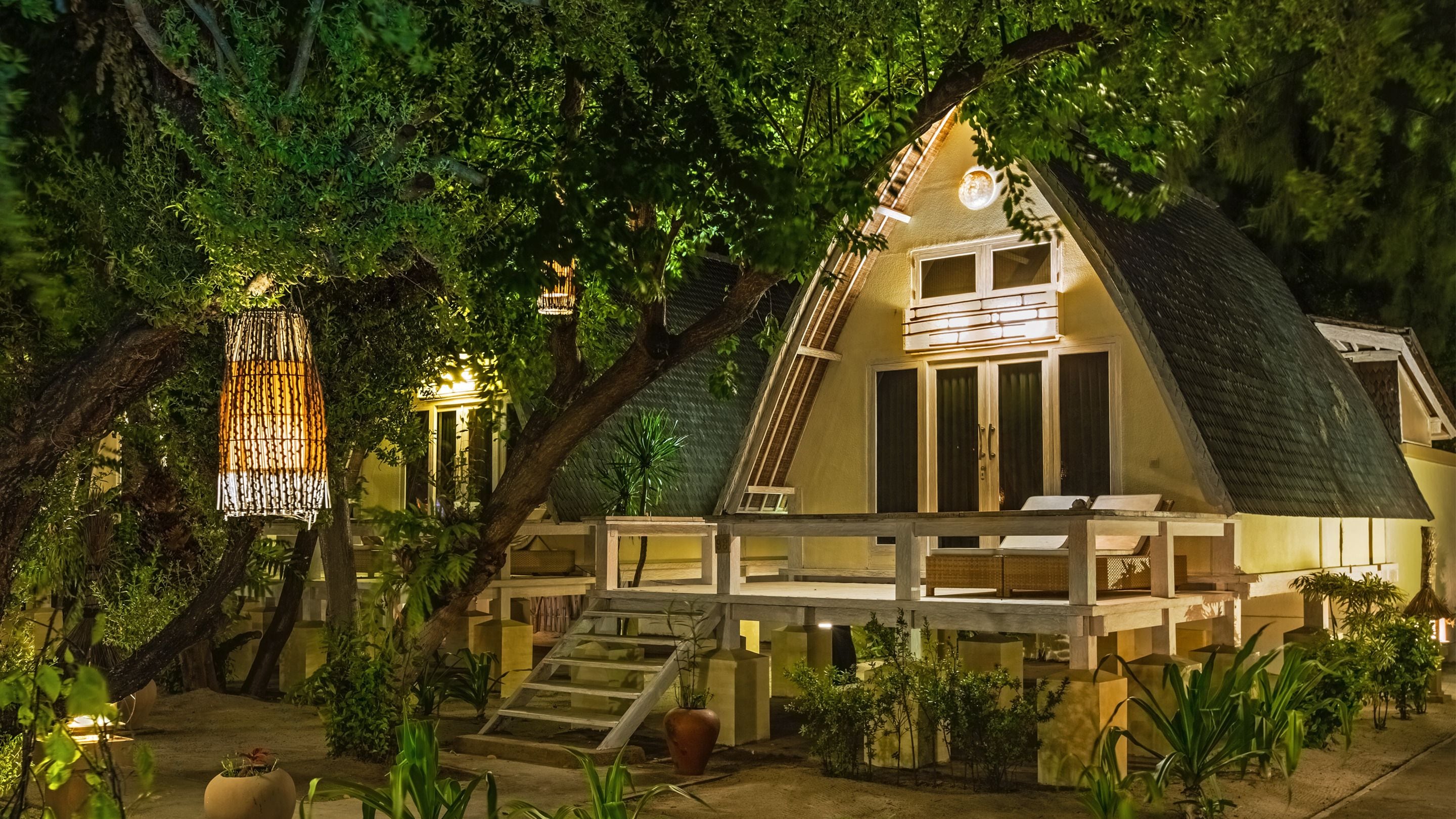 Ein Haus mit geneigtem Dach, einem Balkon und einer Treppe zum Eingang.