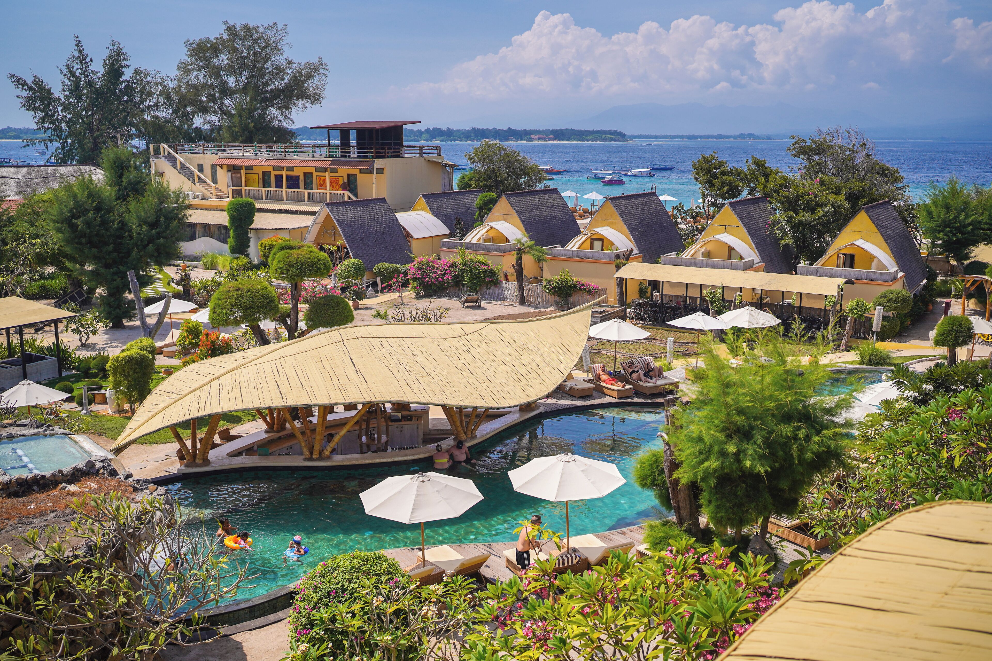 Un resort con piscina, vista al mar y varias cabañas.