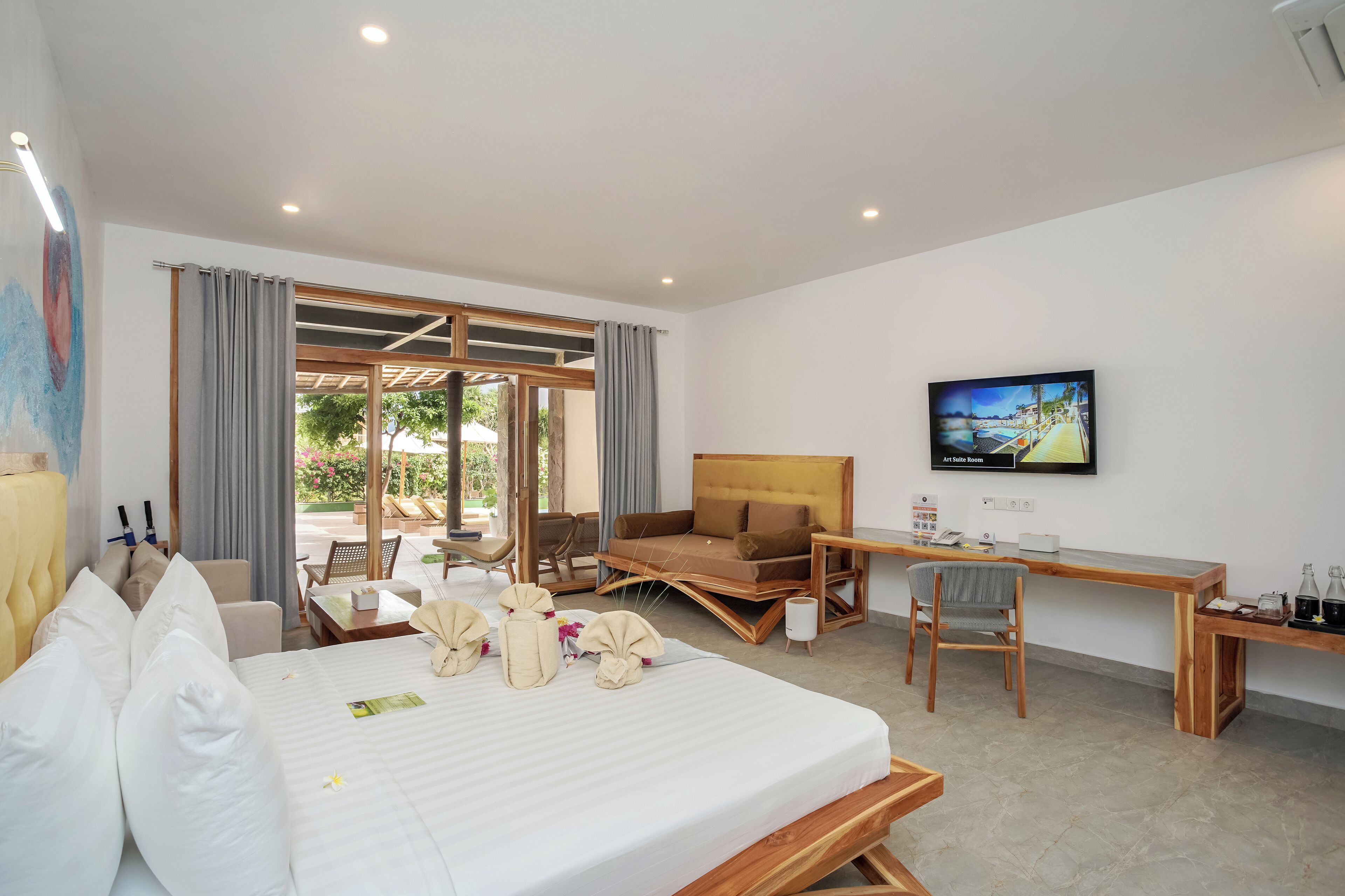 A hotel room with a bed, a desk, a chair, a television, and a view of the outdoors.
