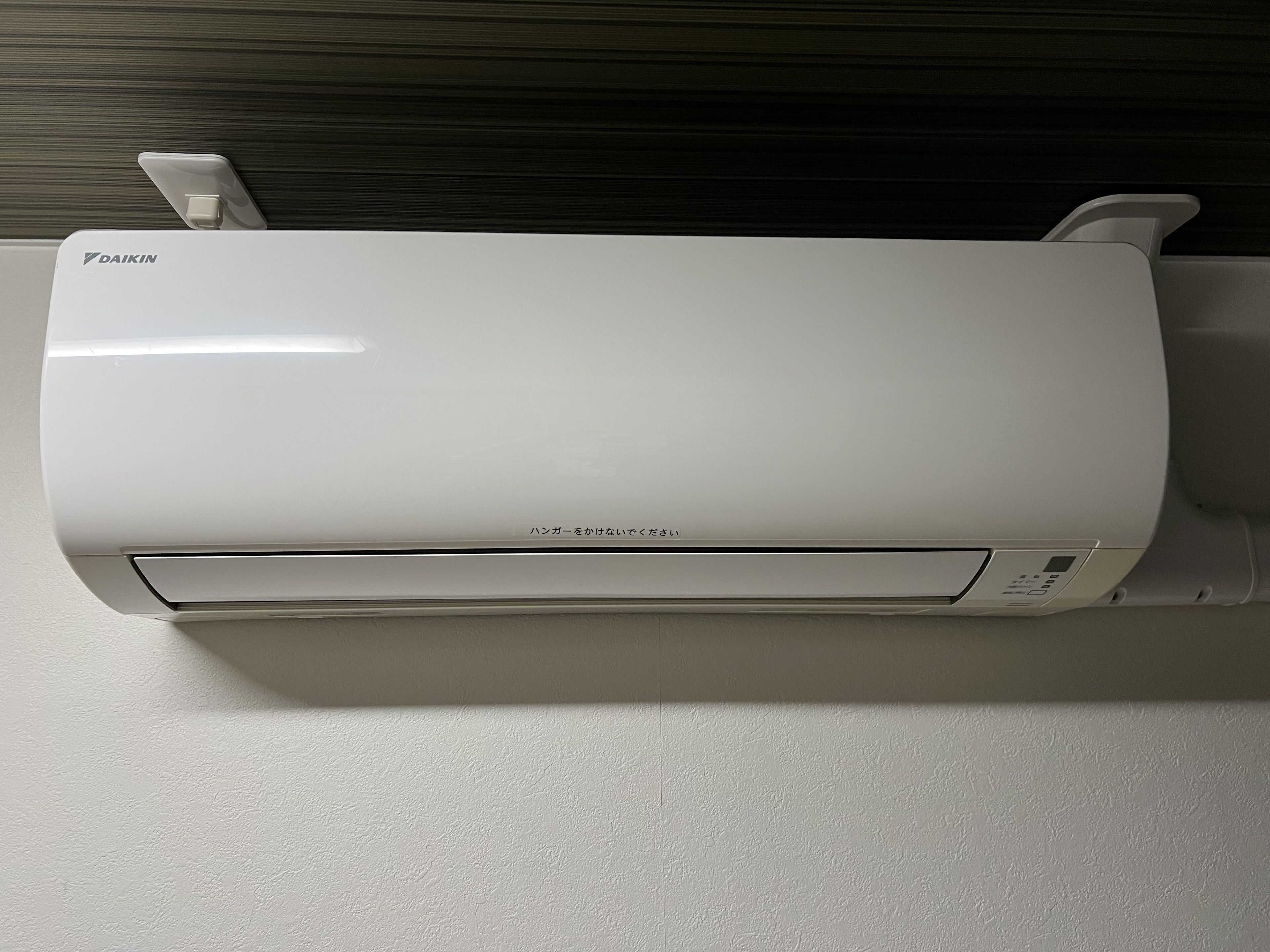 A white Daikin air conditioner unit mounted on a wall.