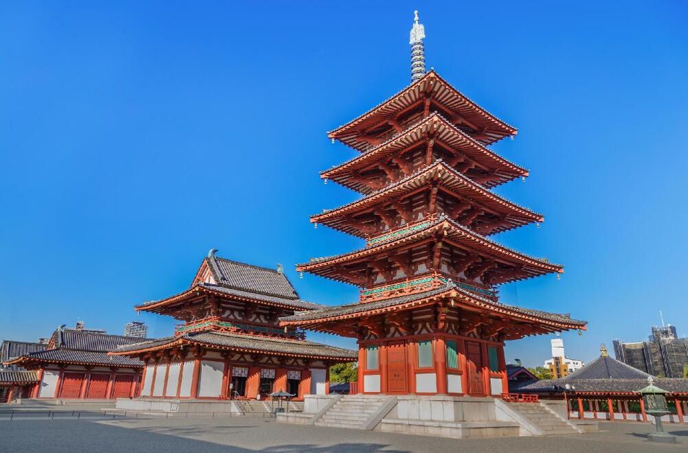 A traditional Japanese pagoda with multiple tiers, surrounded by other buildings.