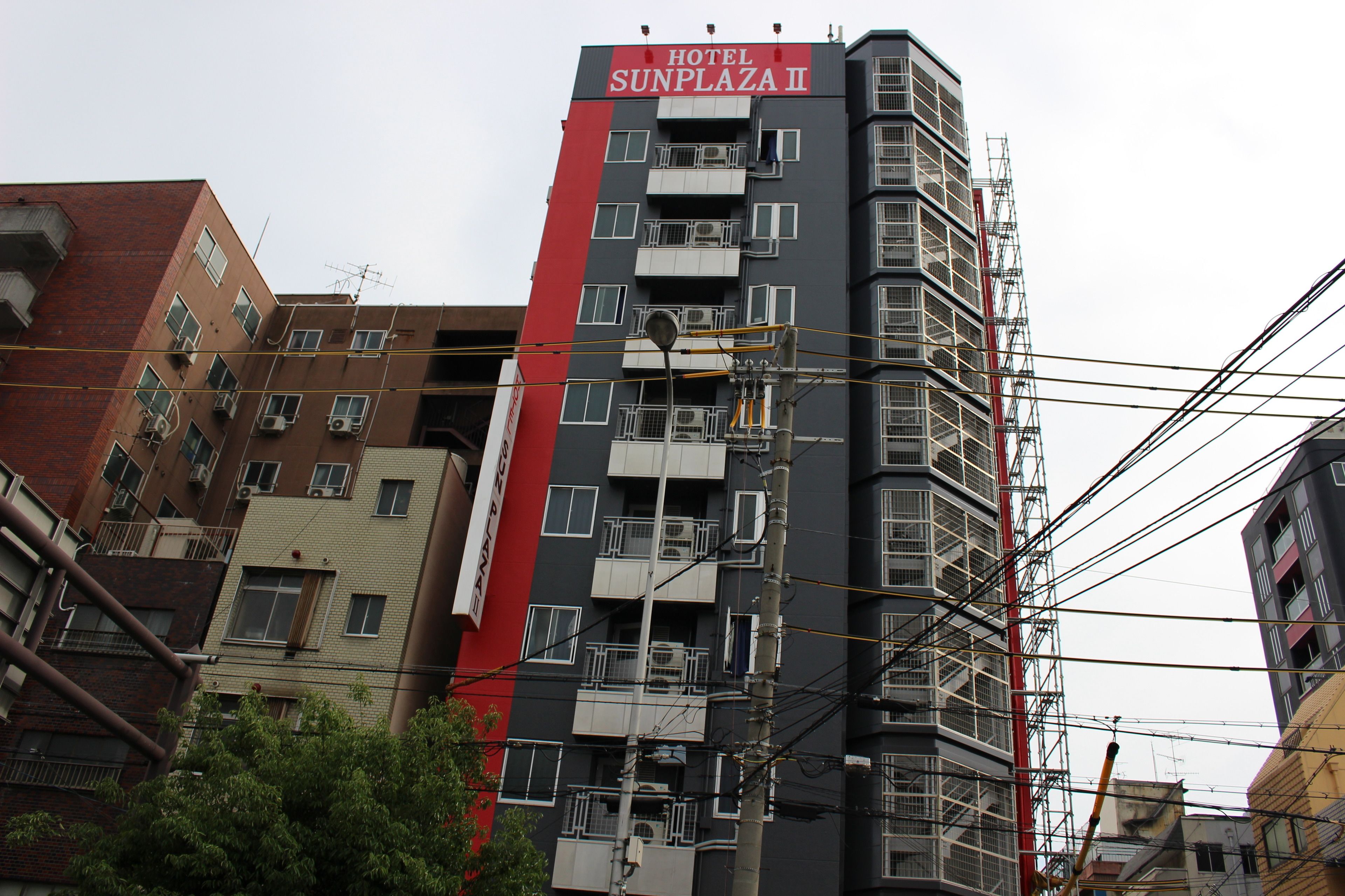 A multi-story building with balconies and air conditioning units, labeled "HOTEL SUNPLAZA II".
