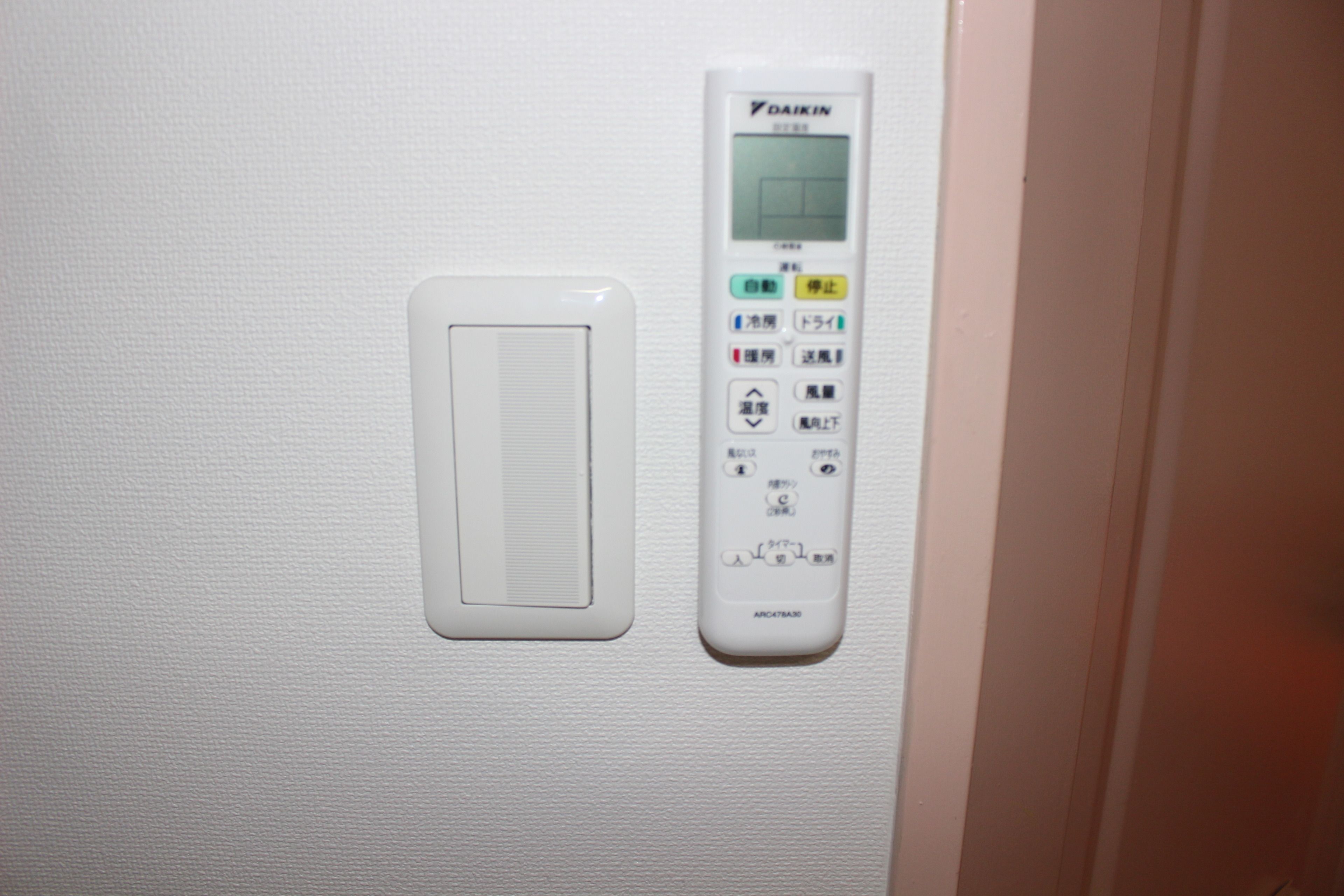 A control panel with buttons and a display screen, likely for room amenities.