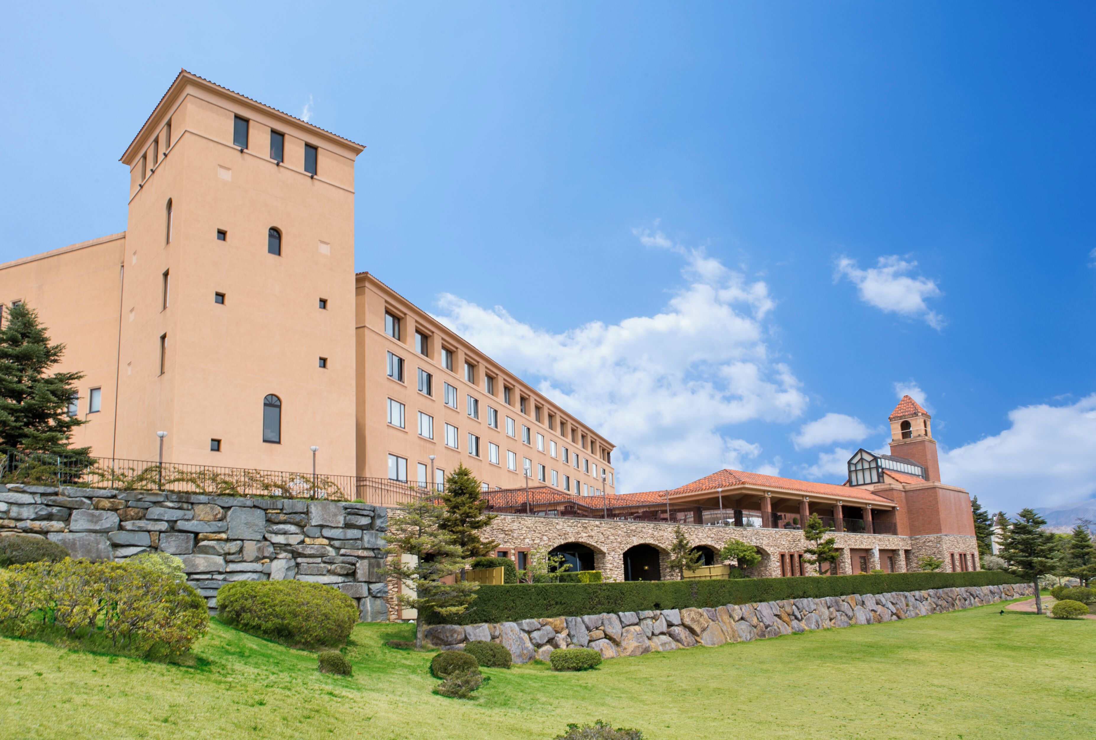 A large hotel with multiple floors, a bell tower, and a stone facade.