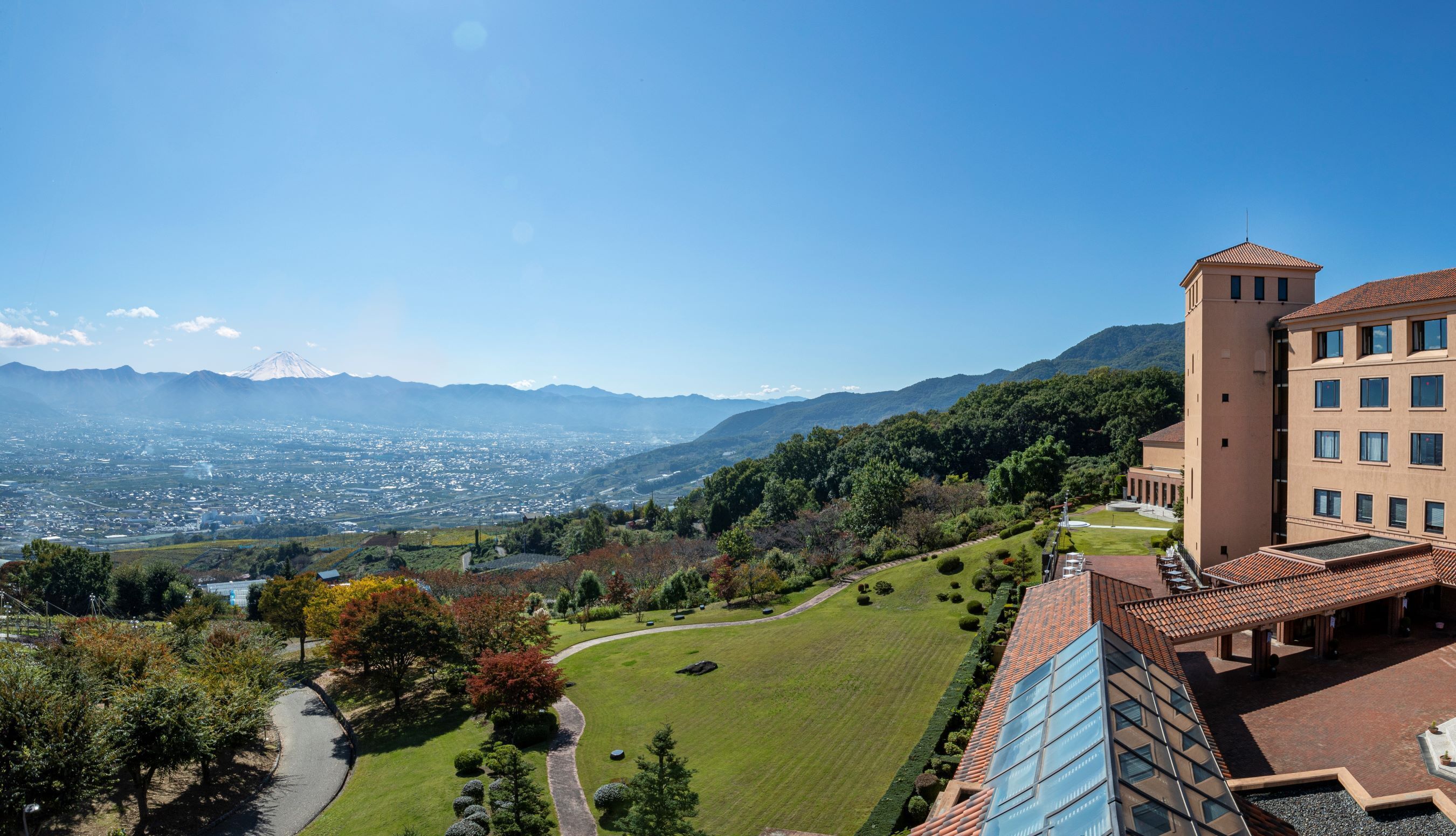 A hotel with a view of a city and mountains.
