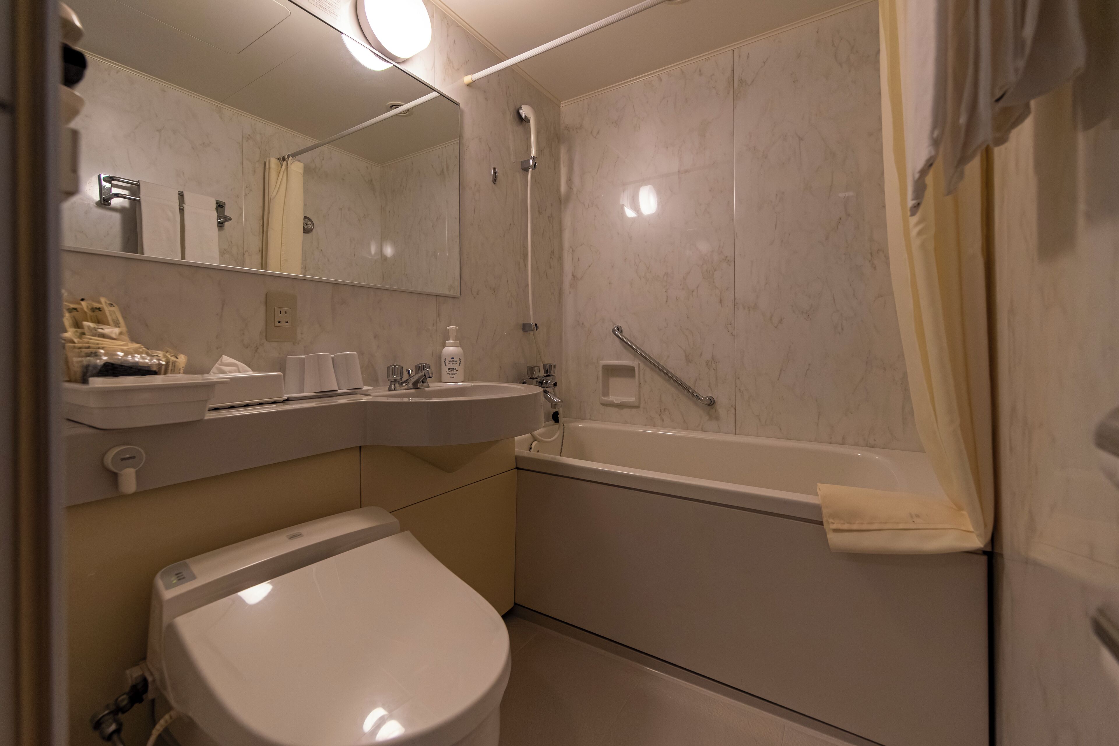 A modern bathroom with a toilet, sink, and bathtub.