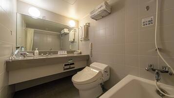 A modern bathroom with a toilet, sink, and bathtub. There is a mirror above the sink, and a towel rack with towels.
