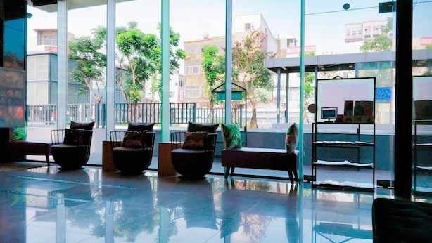 A modern lobby with large windows, a reception desk, and seating areas. - S&E Hotel (Tainan)
