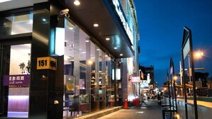 A hotel entrance with a glass facade, a number 151 sign, and a visible interior with seating and decor. - S&E Hotel (Tainan)