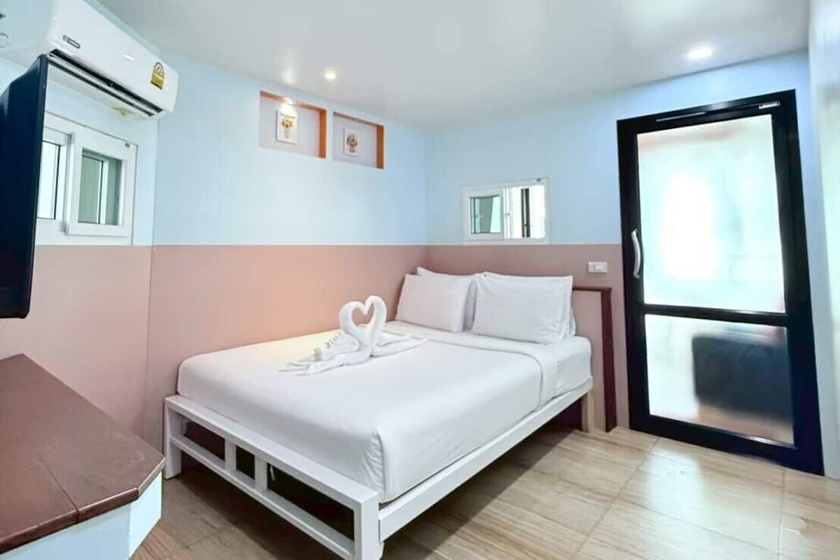 Ein Hotelzimmer mit Bett, Schreibtisch, Klimaanlage und Fenster.