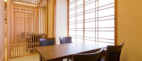 Una habitación tradicional japonesa con suelo de tatami, una mesa de madera baja y puertas correderas shoji.