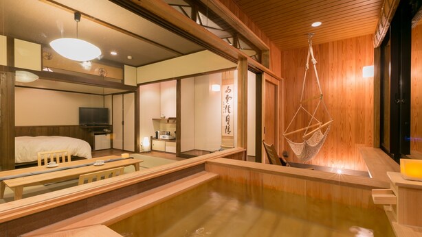 Un onsen japonés tradicional con interiores de madera, un baño de aguas termales y un columpio colgante.