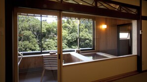 Una habitación con ventanas amplias, un banco de madera y un taburete pequeño.
