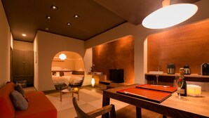 Una habitación de hotel moderna con una zona de estar acogedora, una mesa de comedor y una kitchenette.