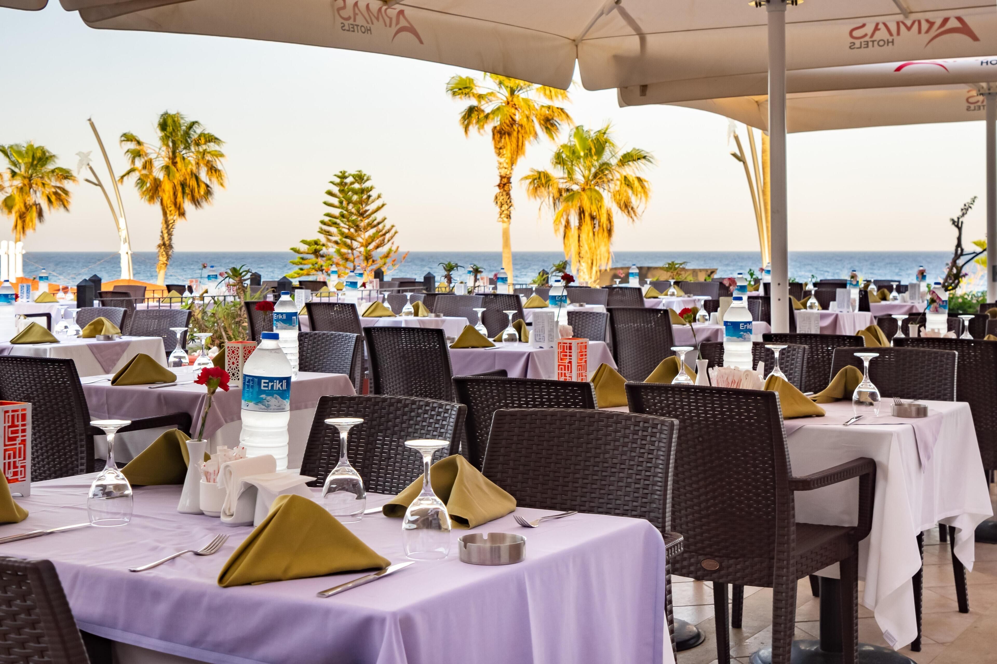 Un restaurante frente al mar, con mesas preparadas para comer.