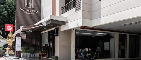 A modern building with a sign reading "DOUBLE TWO @SATHORN".