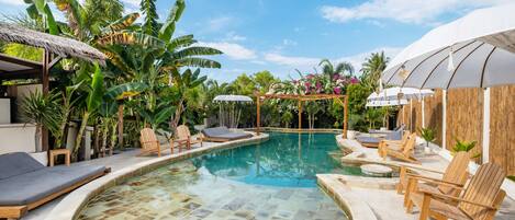 Una piscina al aire libre, sillones reclinables de piscina