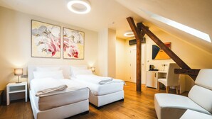 Quarto moderno com cama de casal, escrivaninha e cadeira, piso de madeira e claraboia.