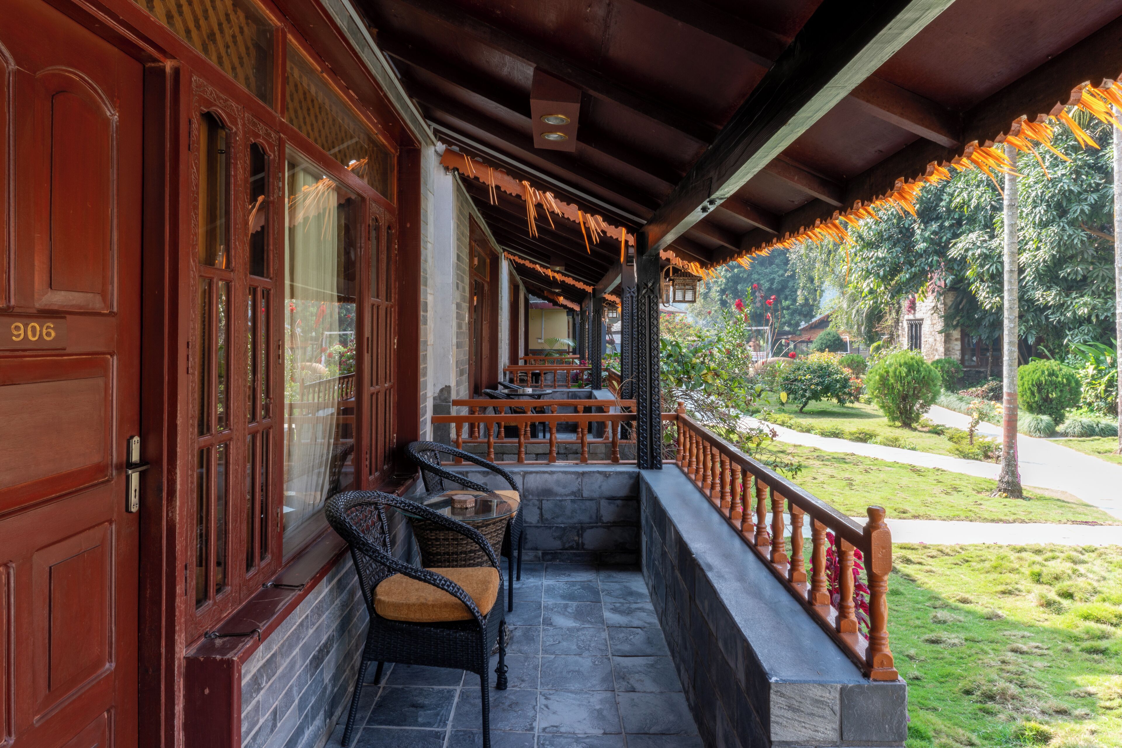 A covered porch with wicker furniture and a stone wall.