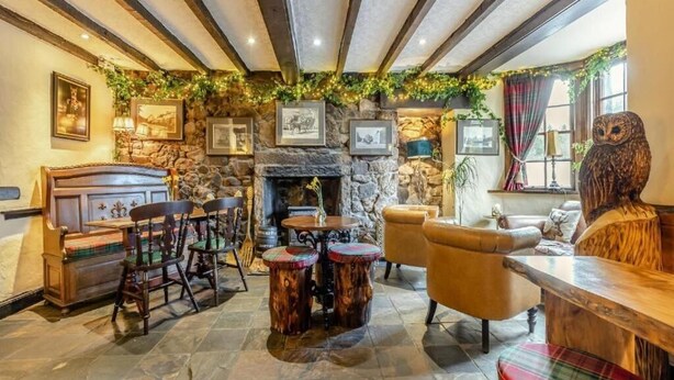 A cozy interior with stone walls, wooden furniture, and a fireplace. - The Tormaukin Hotel (Dollar)