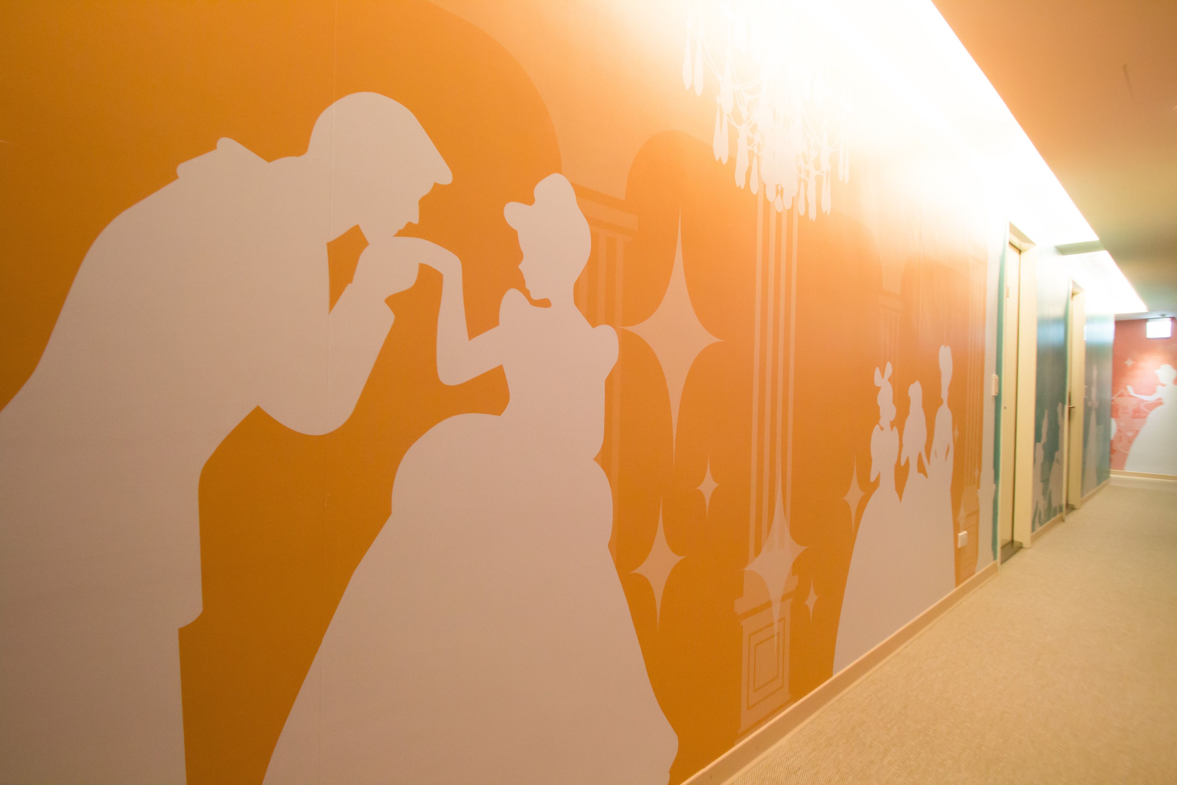 A hallway with a mural of dancing figures.