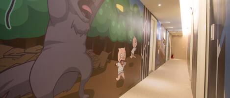 A hallway with a mural of a cartoon character and a child.