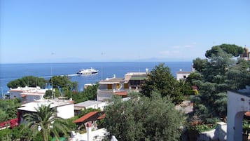 Eine Küstenstadt mit Gebäuden, einem Boot auf dem Meer und einem wolkenlosen Himmel.