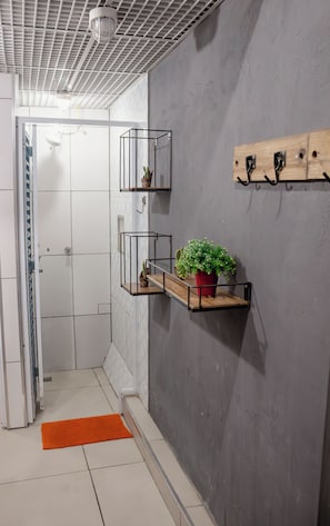 A bathroom with a shower, a towel rack, and a potted plant. - Soul Hostel (São Paulo)