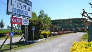 A sign for a hostel named "L'ESPAT" with a contact number and symbols indicating amenities like Wi-Fi and a shower. There's a no-entry sign and a parking sign. - Hostal L´Esplai (Viladamat)