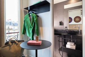 Un baño moderno con un lavabo negro, un espejo y un perchero para toallas.