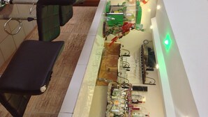 Un espace bar avec des tabourets, un comptoir avec des bouteilles et une horloge murale.