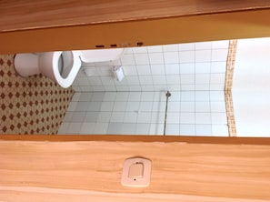 Une salle de bain avec des toilettes, une douche et un carrelage décoratif.