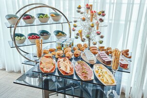 Una mesa de buffet con diversos alimentos y un soporte metálico decorativo.