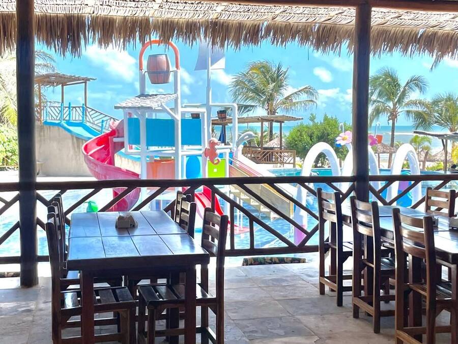 Un área de comedor al aire libre con vista a un parque acuático.