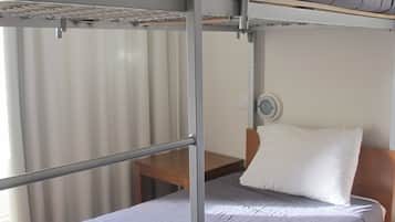 A bunk bed with a grey mattress and a pillow on the lower bunk.