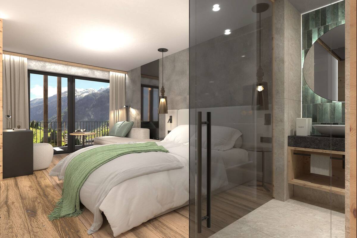 A modern bedroom with a large bed, a glass shower enclosure, and a view of mountains.