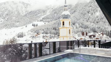 A snow-covered mountain landscape with a church tower and residential buildings.