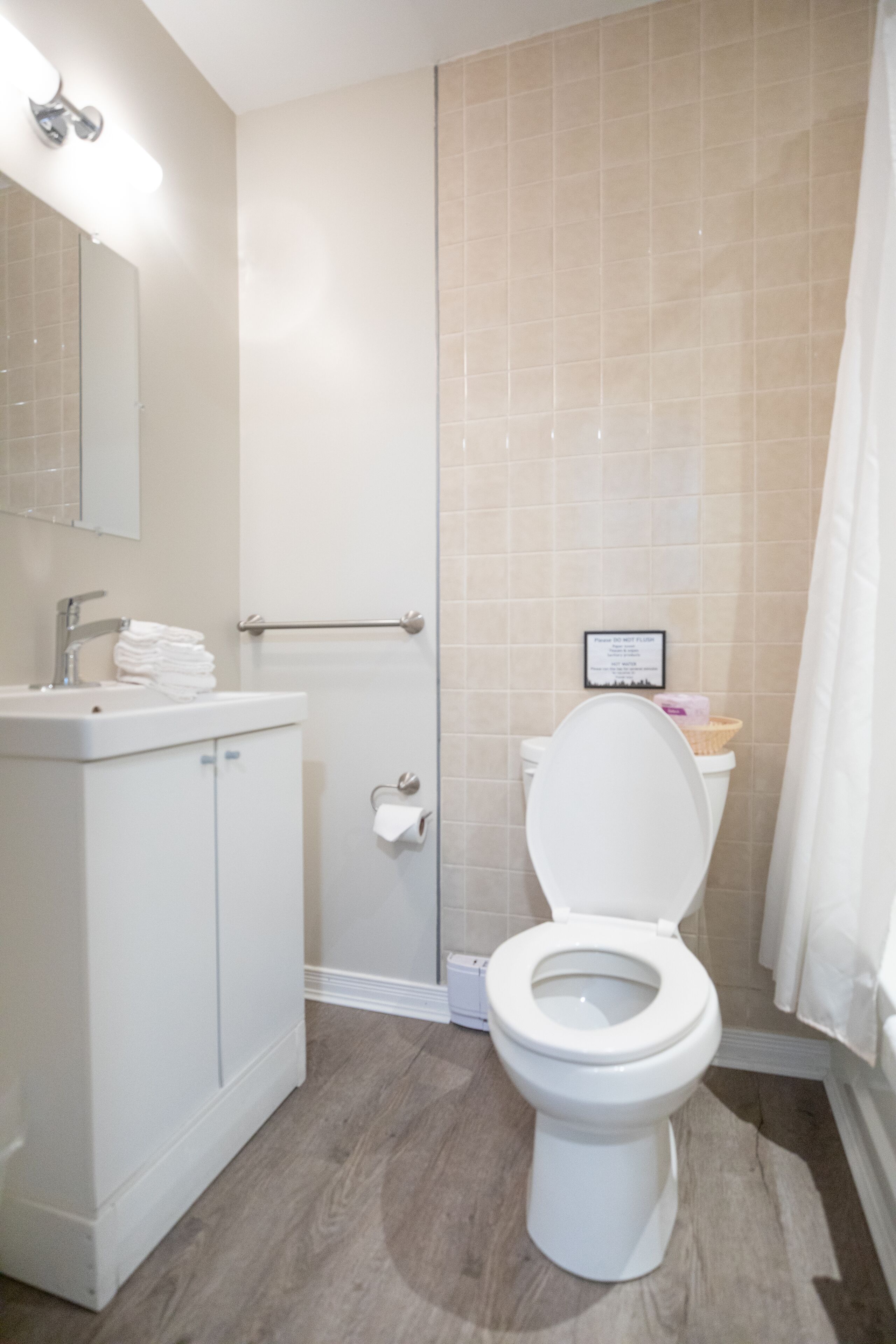 A bathroom with a toilet, sink, and shower.