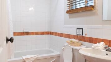 A bathroom with a shower, toilet, bathtub, and sink.